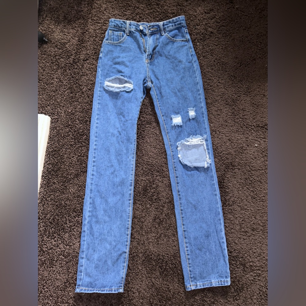 Distressed jeans, damage shown.